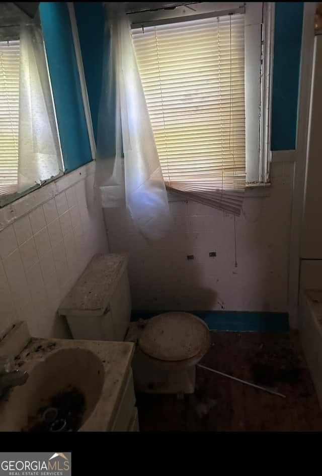 964 Ponce De Leon Cir, Macon, GA 31206 - full bathroom featuring vanity, toilet, tile walls, a bathtub, and plenty of natural light