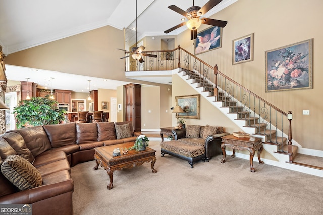 3495 Mill Bridge Dr, Marietta, GA 30062 - carpeted living area featuring ceiling fan, high vaulted ceiling, stairs, crown molding, and baseboards