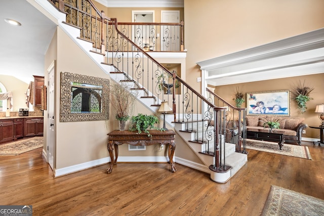 3495 Mill Bridge Dr, Marietta, GA 30062 - stairway with wood finished floors, crown molding, baseboards, a towering ceiling, and recessed lighting