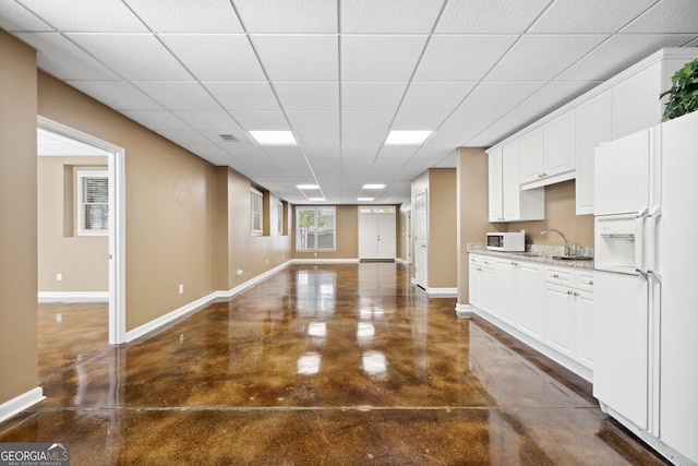 3495 Mill Bridge Dr, Marietta, GA 30062 - kitchen with white appliances, concrete flooring, baseboards, and a drop ceiling