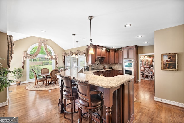 3495 Mill Bridge Dr, Marietta, GA 30062 - kitchen with light stone countertops, a breakfast bar, stainless steel appliances, a sink, and light wood-style flooring