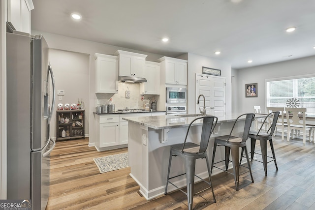 390 Cushing St, Senoia, GA 30276 - kitchen featuring stainless steel appliances, a sink, light wood finished floors, white cabinetry, and recessed lighting