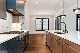 320 Dodd Ln, Alpharetta, GA 30005 - kitchen with wall chimney range hood, a sink, dark wood finished floors, pendant lighting, and baseboards