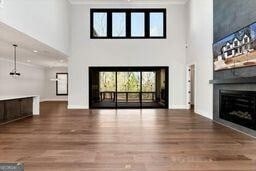 320 Dodd Ln, Alpharetta, GA 30005 - unfurnished living room with a fireplace, a high ceiling, wood finished floors, ornamental molding, and baseboards