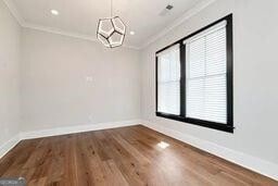 320 Dodd Ln, Alpharetta, GA 30005 - unfurnished dining area with crown molding, baseboards, and wood finished floors