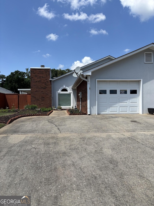 135 Courtyard Ln, Fayetteville, GA 30215 - view of front of house featuring concrete driveway, stucco siding, a garage, and brick siding