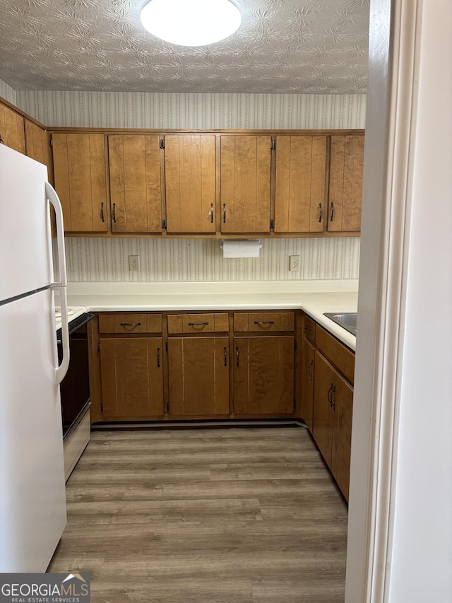 135 Courtyard Ln, Fayetteville, GA 30215 - kitchen featuring freestanding refrigerator, electric range oven, brown cabinets, and light countertops
