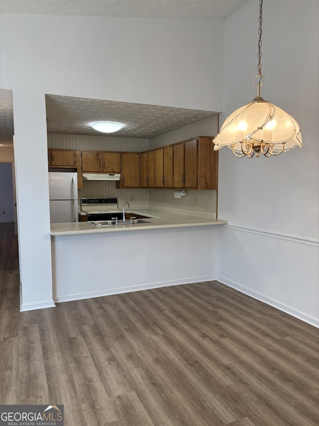 135 Courtyard Ln, Fayetteville, GA 30215 - kitchen with freestanding refrigerator, dark wood-style flooring, brown cabinets, and under cabinet range hood
