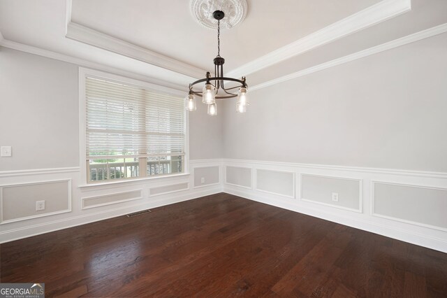 6585 Canyon Cv, Cumming, GA 30028 - empty room featuring a chandelier, a raised ceiling, ornamental molding, dark wood-type flooring, and wainscoting