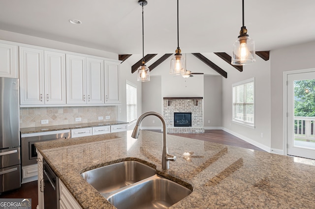 6585 Canyon Cv, Cumming, GA 30028 - kitchen featuring appliances with stainless steel finishes, hanging light fixtures, white cabinets, tasteful backsplash, and recessed lighting