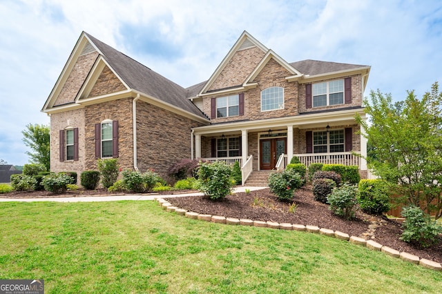 6585 Canyon Cv, Cumming, GA 30028 - craftsman-style house featuring a front lawn, covered porch, stone siding, and brick siding