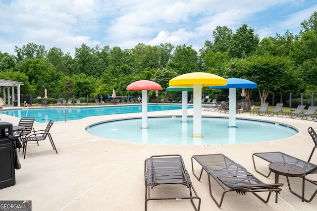 6585 Canyon Cv, Cumming, GA 30028 - community pool with a water play area, a patio area, and view of scattered trees