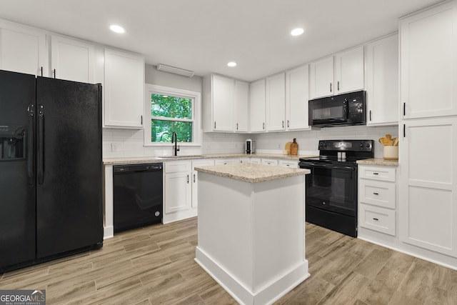 2121 Elysian Cir, Gainesville, GA 30501 - kitchen featuring black appliances, white cabinets, decorative backsplash, a sink, and light wood finished floors