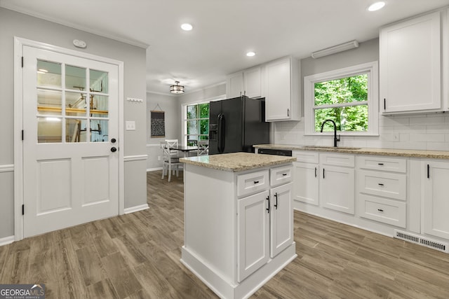 2121 Elysian Cir, Gainesville, GA 30501 - kitchen with black refrigerator with ice dispenser, backsplash, light wood-style floors, recessed lighting, and crown molding