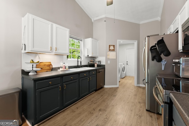 7277 Plum Creek Dr, Gainesville, GA 30507 - kitchen featuring a sink, washing machine and dryer, appliances with stainless steel finishes, crown molding, and white cabinetry