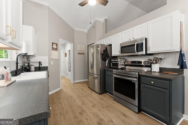 7277 Plum Creek Dr, Gainesville, GA 30507 - kitchen featuring appliances with stainless steel finishes, dark countertops, white cabinetry, a sink, and crown molding
