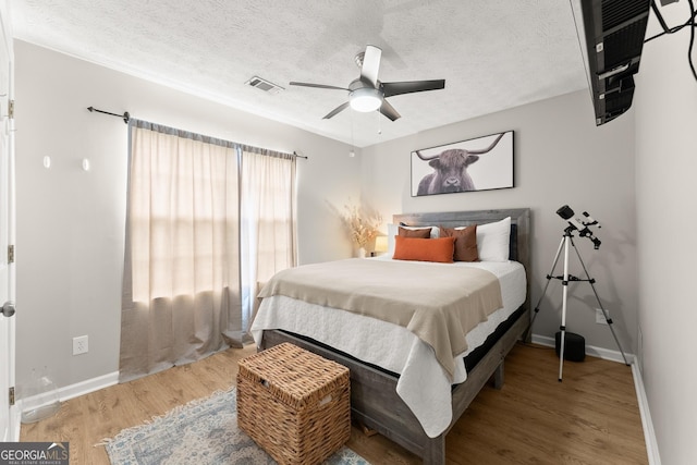 7277 Plum Creek Dr, Gainesville, GA 30507 - bedroom with light wood-style flooring, baseboards, a textured ceiling, and ceiling fan