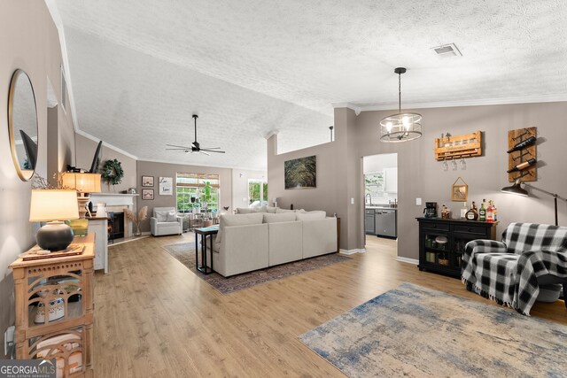 7277 Plum Creek Dr, Gainesville, GA 30507 - living area with a textured ceiling, vaulted ceiling, light wood finished floors, a lit fireplace, and ceiling fan