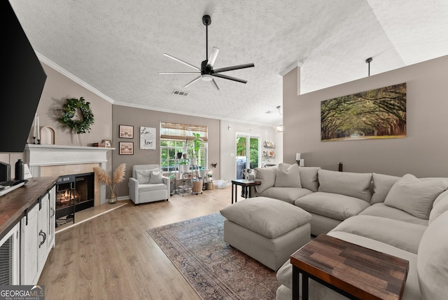 7277 Plum Creek Dr, Gainesville, GA 30507 - living area with a ceiling fan, light wood finished floors, ornamental molding, a textured ceiling, and a fireplace