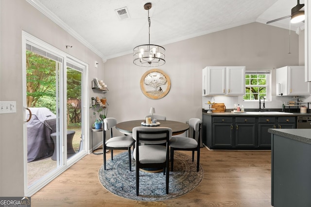 7277 Plum Creek Dr, Gainesville, GA 30507 - dining area featuring crown molding, light wood-type flooring, lofted ceiling, a ceiling fan, and a chandelier