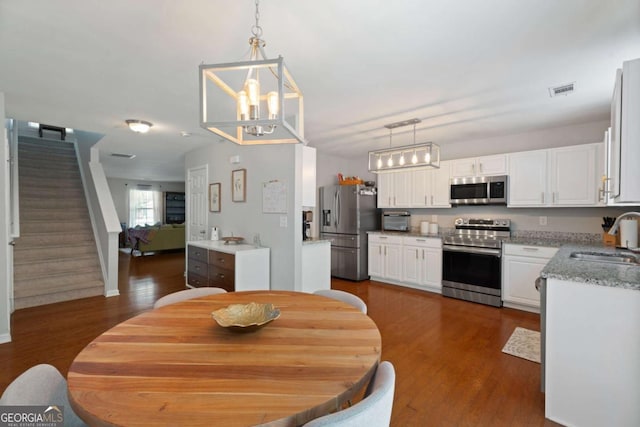 3420 Griffin Way, Cumming, GA 30040 - dining area featuring a chandelier, dark wood finished floors, and stairway