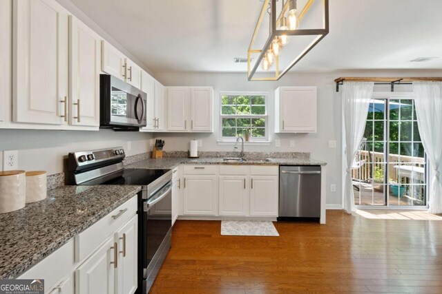 3420 Griffin Way, Cumming, GA 30040 - kitchen with stainless steel appliances, a sink, wood finished floors, and white cabinetry