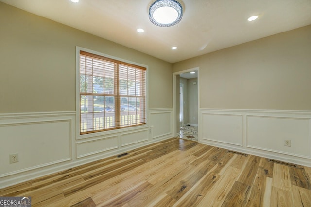 2436 Green Hollow Ct, Conyers, GA 30012 - spare room with wood finished floors, a decorative wall, wainscoting, and recessed lighting