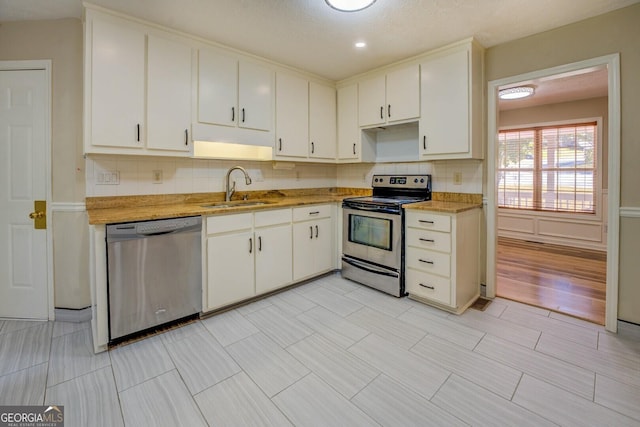 2436 Green Hollow Ct, Conyers, GA 30012 - kitchen with stainless steel appliances, a sink, white cabinetry, and decorative backsplash