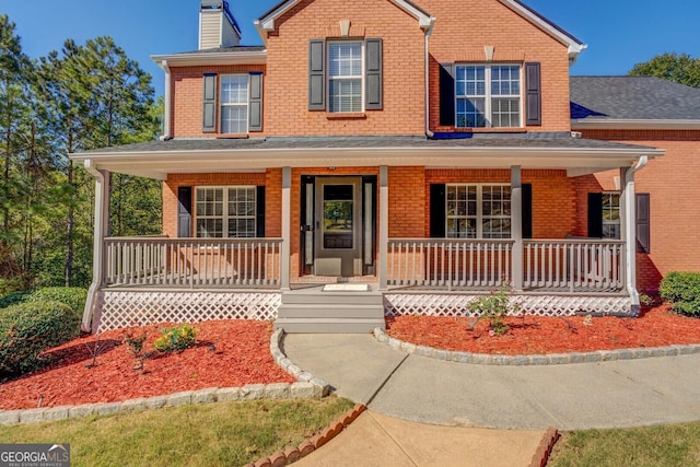 2436 Green Hollow Ct, Conyers, GA 30012 - traditional-style home featuring brick siding, covered porch, and a chimney