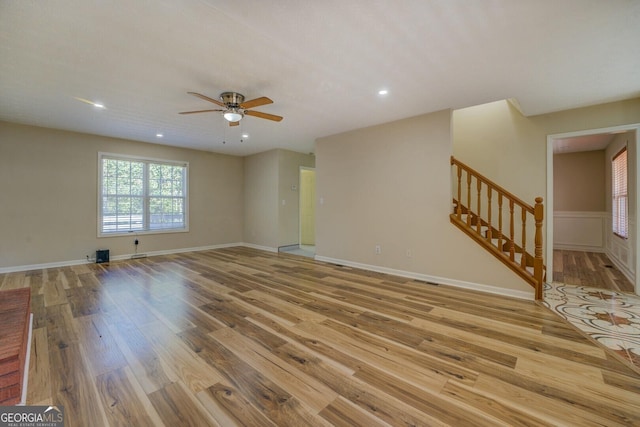 2436 Green Hollow Ct, Conyers, GA 30012 - unfurnished living room with wood finished floors, a ceiling fan, stairs, recessed lighting, and baseboards
