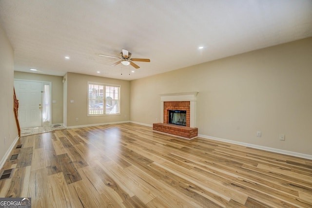 2436 Green Hollow Ct, Conyers, GA 30012 - unfurnished living room with light wood-style floors, a ceiling fan, recessed lighting, baseboards, and a brick fireplace