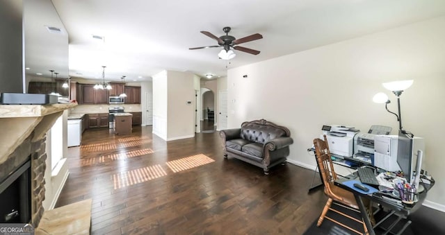 8744 Hamil Ct, Douglasville, GA 30135 - living area featuring arched walkways, ceiling fan, dark wood-type flooring, a stone fireplace, and baseboards