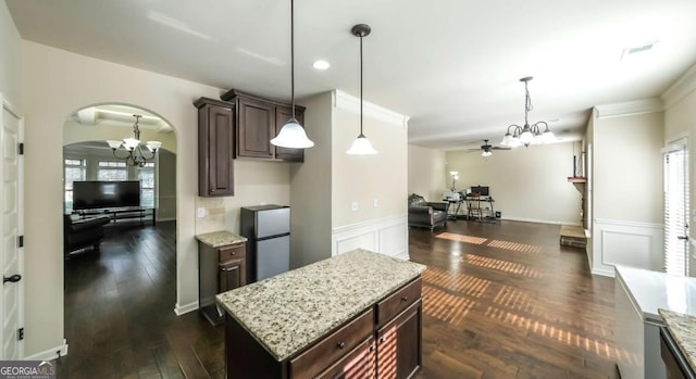 8744 Hamil Ct, Douglasville, GA 30135 - kitchen with arched walkways, a chandelier, freestanding refrigerator, ceiling fan, and dark brown cabinets