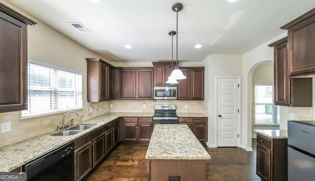 8744 Hamil Ct, Douglasville, GA 30135 - kitchen with appliances with stainless steel finishes, a sink, arched walkways, dark wood-style floors, and tasteful backsplash