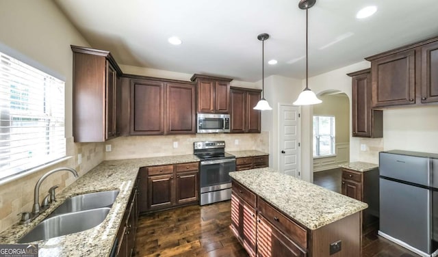 8744 Hamil Ct, Douglasville, GA 30135 - kitchen with appliances with stainless steel finishes, a sink, arched walkways, plenty of natural light, and recessed lighting