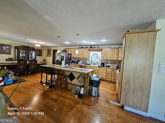 30 Glen View Dr NE, Rome, GA 30165 - kitchen with stainless steel fridge, light wood-style flooring, a textured ceiling, light countertops, and light brown cabinetry