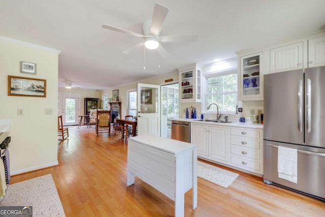 1020 Belmont Rd, Athens, GA 30605 - kitchen featuring appliances with stainless steel finishes, a sink, a ceiling fan, light wood-type flooring, and ornamental molding