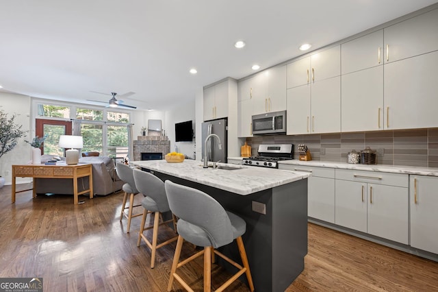 1308 NE Fernwood Cir NE, Atlanta, GA 30319 - kitchen with stainless steel appliances, a sink, a breakfast bar area, backsplash, and recessed lighting