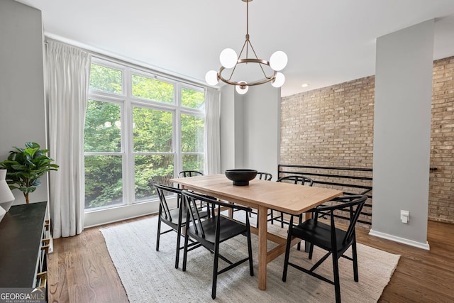 1308 NE Fernwood Cir NE, Atlanta, GA 30319 - dining room featuring brick wall, a chandelier, wood finished floors, and baseboards