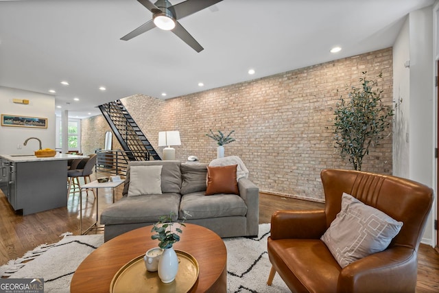 1308 NE Fernwood Cir NE, Atlanta, GA 30319 - living room featuring brick wall, wood finished floors, stairs, a ceiling fan, and recessed lighting