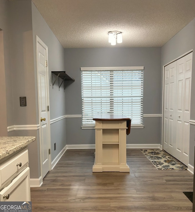 165 Woodgate Cir, Fayetteville, GA 30214 - unfurnished dining area featuring a textured ceiling, dark wood-type flooring, and baseboards
