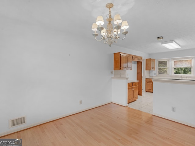 114 Overlook Dr, Mcdonough, GA 30252 - kitchen featuring a chandelier, light wood-type flooring, light countertops, and baseboards