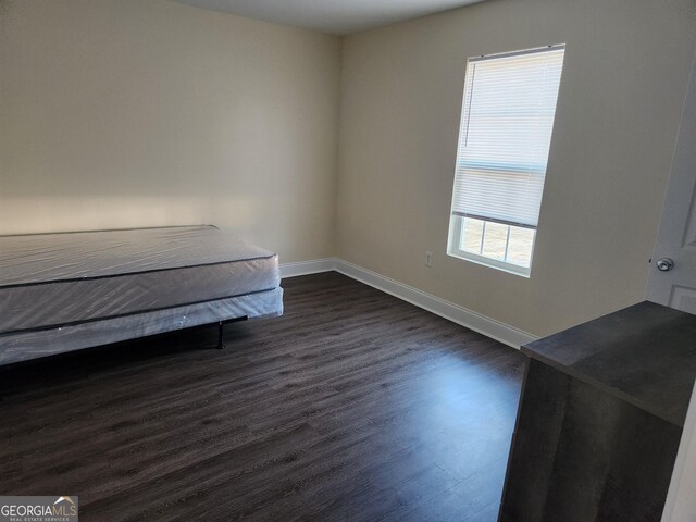 108 Ronald Pride, Fort Valley, GA 31030 - unfurnished bedroom featuring dark wood finished floors and baseboards