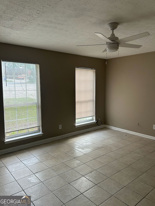 1321 Lakeview Dr NW, Conyers, GA 30012 - empty room with light tile patterned floors, a ceiling fan, a textured ceiling, and baseboards
