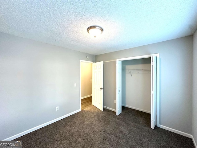 3170 W Point Cir, Douglasville, GA 30135 - unfurnished bedroom with dark carpet, a closet, baseboards, and a textured ceiling