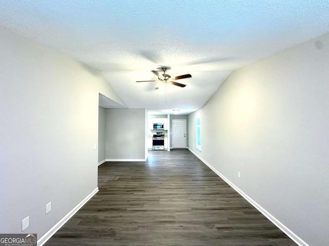 3170 W Point Cir, Douglasville, GA 30135 - unfurnished living room with a ceiling fan, dark wood-type flooring, baseboards, lofted ceiling, and a textured ceiling