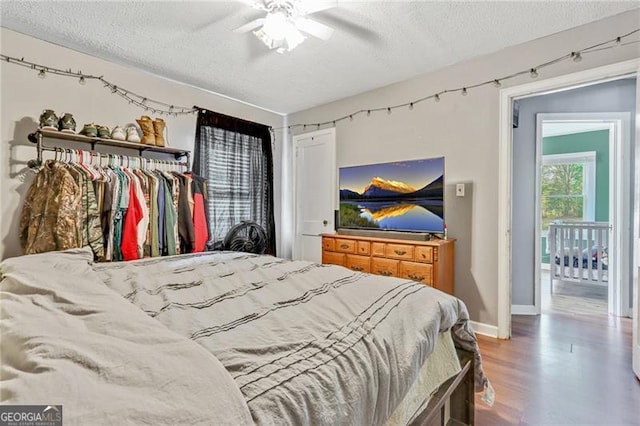 118 Greenwood St, Fairburn, GA 30213 - bedroom with a textured ceiling, wood finished floors, a ceiling fan, and baseboards