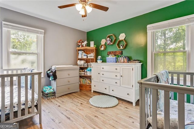 118 Greenwood St, Fairburn, GA 30213 - bedroom featuring a crib, multiple windows, wood finished floors, and ceiling fan