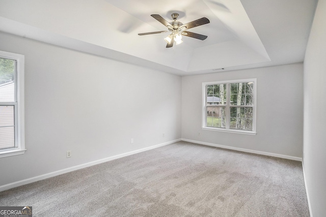 2681 Lakeside Dr SW, Conyers, GA 30094 - empty room with plenty of natural light, a raised ceiling, carpet floors, and a ceiling fan