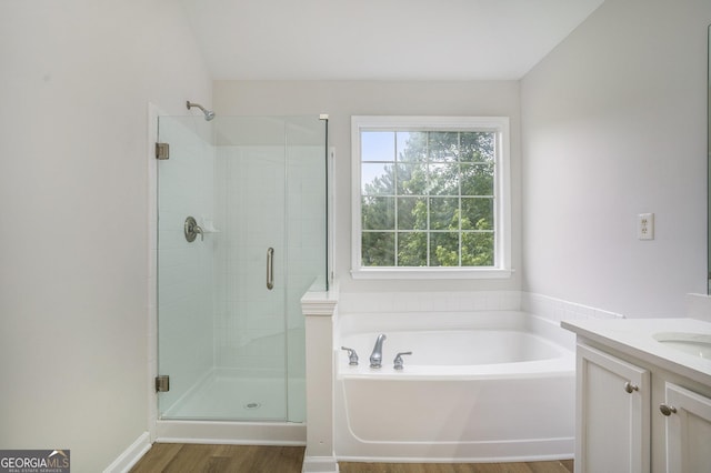 2681 Lakeside Dr SW, Conyers, GA 30094 - bathroom with wood finished floors, a garden tub, vanity, and a stall shower